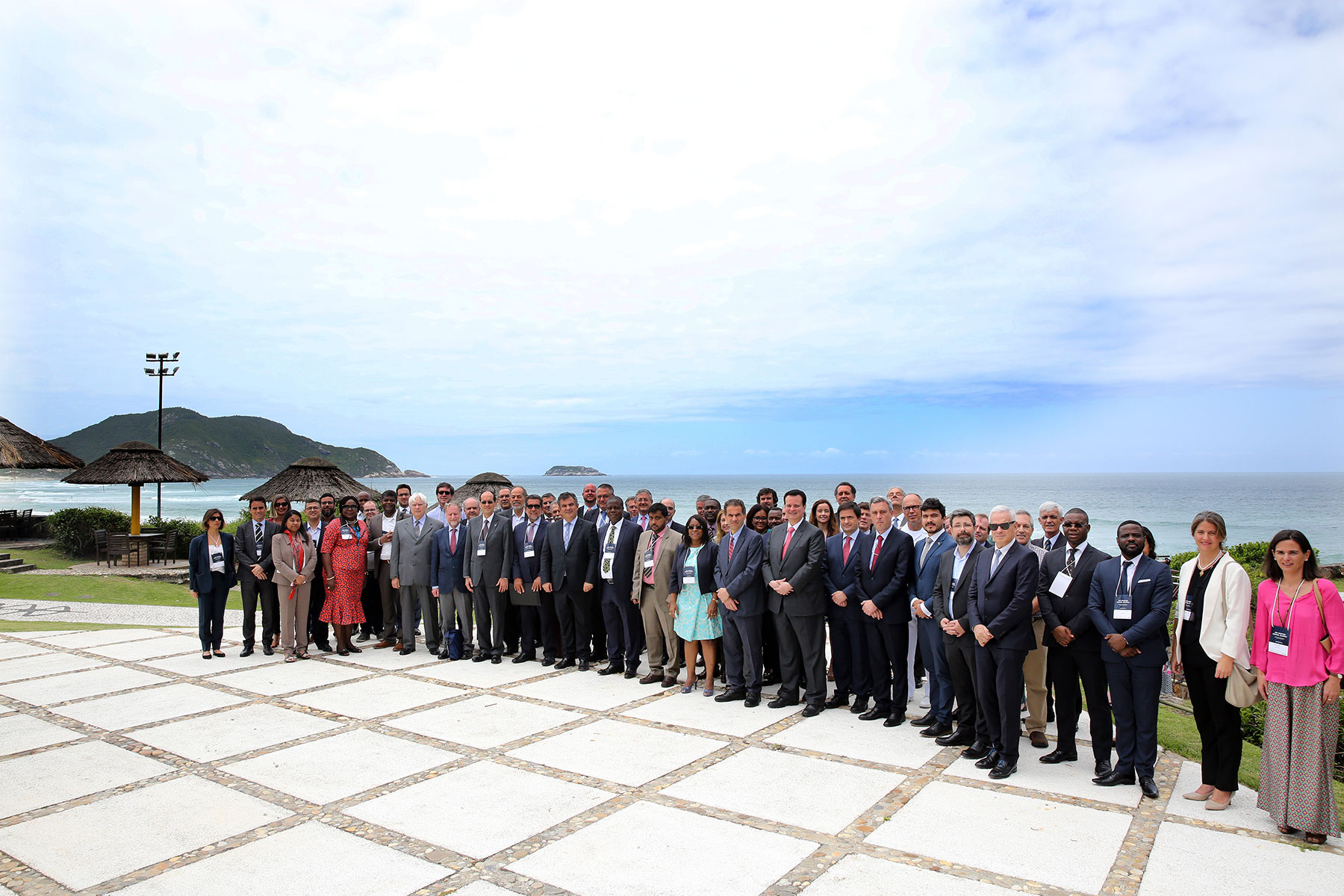 Group of attendees from the Second High-Level Industry-Science-Government Dialogue on Atlantic Interactions stand on the beach in Florianopolis, Brazil